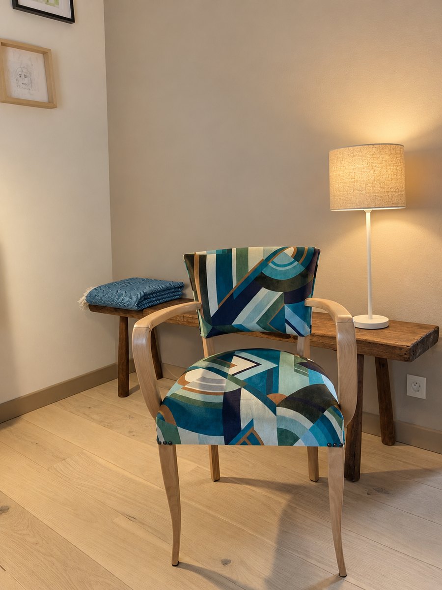 Fauteuil bridge recouvert d'un tissu graphique bleu, dans un intérieur